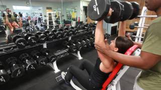 woman with a trainor lifting weights