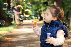 young girl blowing bubbles